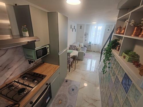 a kitchen with a stove and a living room at Casetta sul mare in Savona