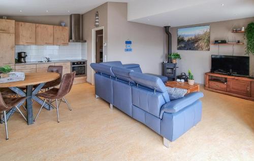 a living room with a blue couch and a table at 2 Bedroom Awesome Home In Callantsoog in Callantsoog