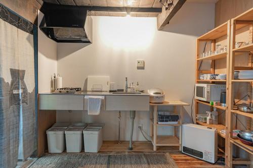 a kitchen with a counter and a sink in a room at 古民家 飛鳥 in Atami