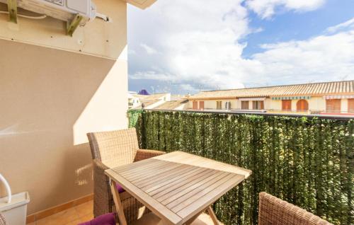 a table and chairs on a balcony with a green wall at Awesome Apartment In Los Alcazares in Los Alcázares