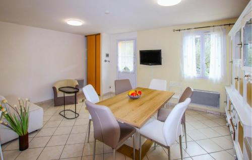 a dining room with a wooden table and white chairs at 2 Bedroom Amazing Home In Chassiers in Chassiers