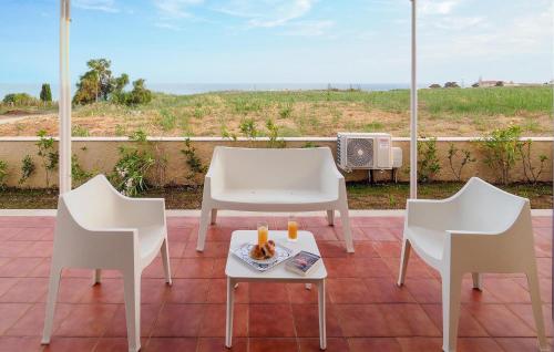 eine Terrasse mit 2 Stühlen und einem Tisch mit Getränken darauf in der Unterkunft 1 Bedroom Cozy Home In Marina Di Modica in Marina di Modica