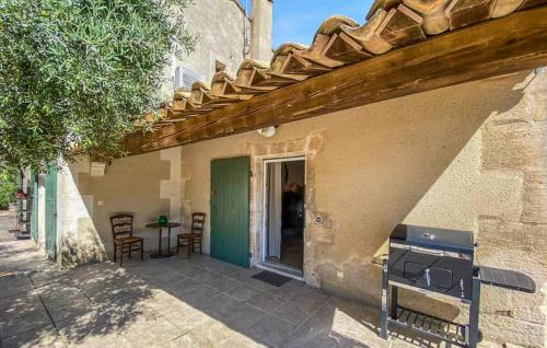 un patio avec une table et des chaises à côté d'un bâtiment dans l'établissement Amazing Home In Maussane-Les-Alpilles, à Maussane-les-Alpilles