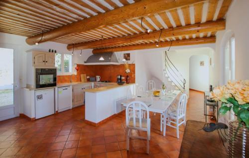 une cuisine avec une table et des chaises dans une pièce dans l'établissement Sarriette Romarin, à Apt