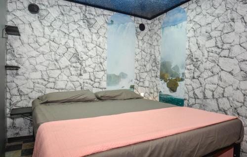 a bed in a room with a stone wall at Casa Vacanze Kandinsky in Monterosso Almo