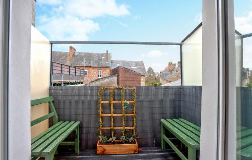a balcony with two green benches and a window at 1 Bedroom Cozy Apartment In Carolles in Carolles