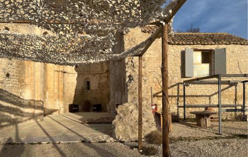 un bâtiment en pierre avec un banc devant lui dans l'établissement 1 Bedroom Gorgeous Home In Orgon, à Orgon