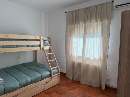 a bedroom with a bunk bed and a window at Cantarranas in Los Hinojosos