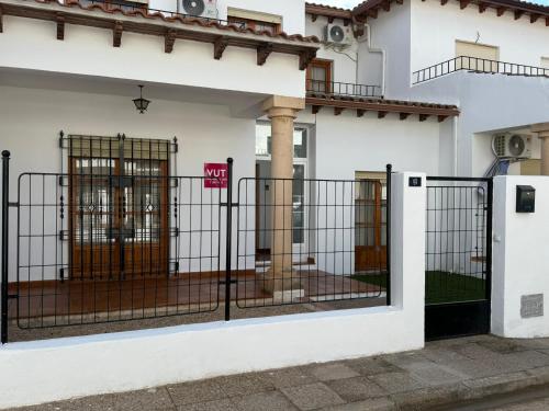 a white house with a gate in front of it at Cantarranas in Los Hinojosos