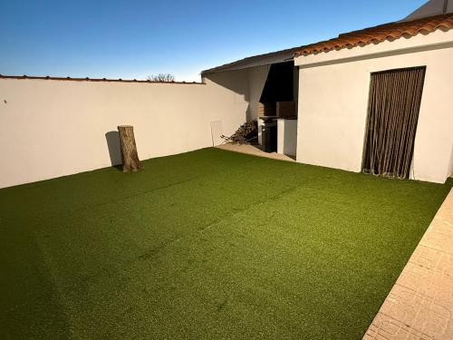 a backyard with a green lawn in front of a house at Cantarranas in Los Hinojosos