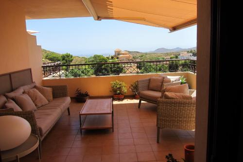 a living room with couches and a table and a balcony at Apartamento duplex en resort de golf y playa in Atamaría