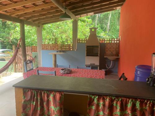 a patio with a table and chairs in a house at Suítes Vila do Surf , a original , desde 2010 in Ubatuba