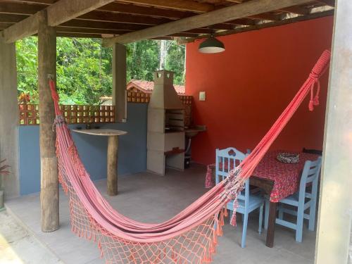 a hammock on the porch of a house at Suítes Vila do Surf , a original , desde 2010 in Ubatuba