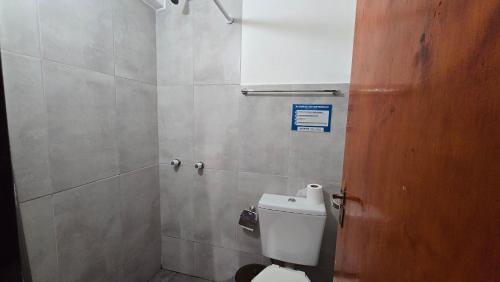 a bathroom with a toilet and a sign on the door at Hotel y Restaurant AKATA in Río Mayo