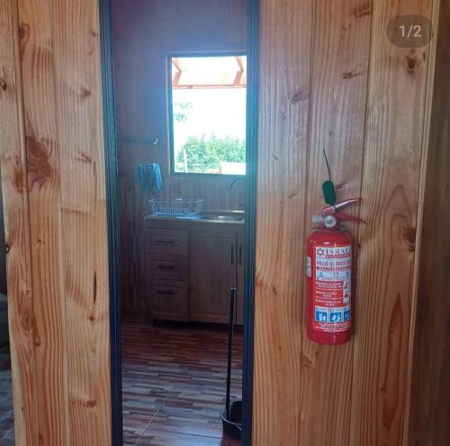 a fire extinguisher hanging on the wall of a kitchen at Cabaña Moebius Conaripe in Panguipulli