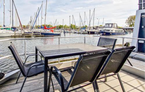 a table and chairs on a dock with boats in the water at Johannesburg in Naarden