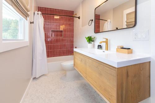 a bathroom with a sink and a toilet and a mirror at The Dogwood in Maggie Valley