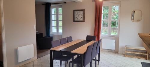 une salle à manger avec une table et des chaises en bois dans l'établissement Maison proche étang et circuit vélo, à Martigné-Ferchaud