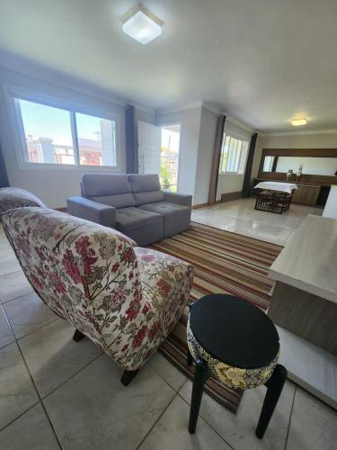 ein Wohnzimmer mit Sofa und Tisch in der Unterkunft Casa temporada em Xangri-Lá in Xangri-lá