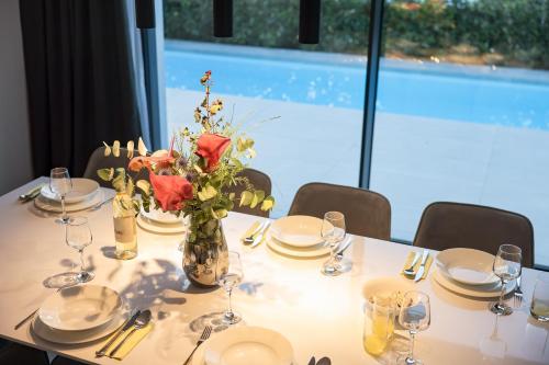 a white table with a vase of flowers on it at Villa Magic Sky II in Kraj
