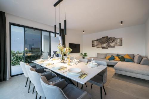 a dining room and living room with a table and chairs at Villa Magic Sky II in Kraj