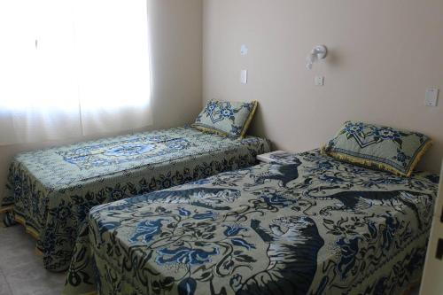 een slaapkamer met twee bedden en een raam bij Atalaya in Puerto Madryn