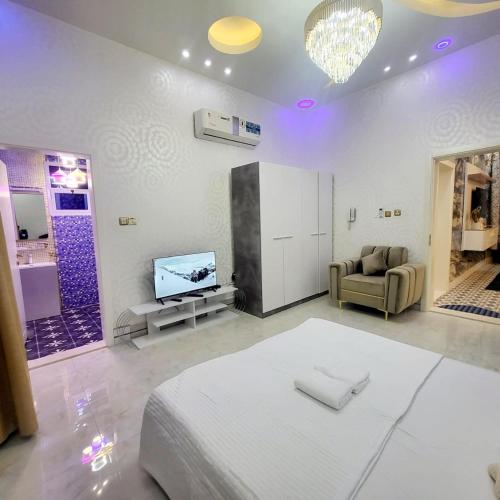a living room with a bed and a tv at Beachfront Holiday Homes in Ajman 