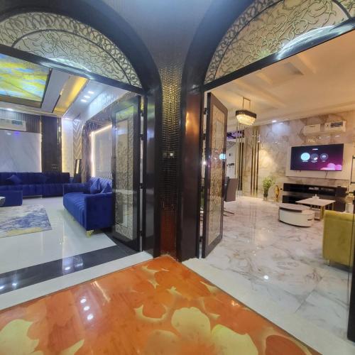 a living room with a blue couch and a tv at Beachfront Holiday Homes in Ajman 