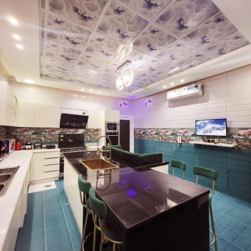a kitchen with purple lights on the ceiling at Beachfront Holiday Homes in Ajman 