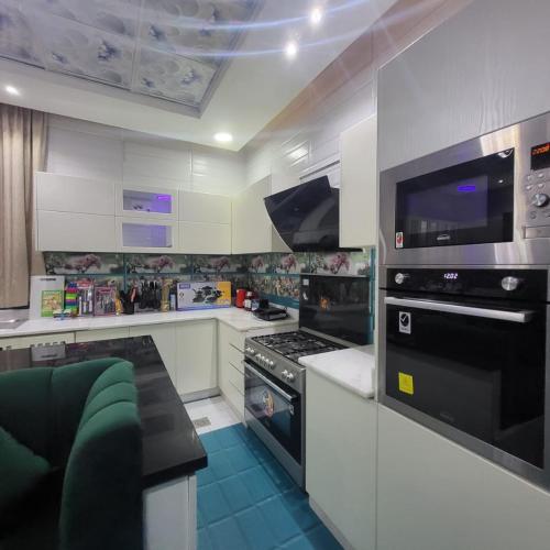 a kitchen with white cabinets and black appliances at Beachfront Holiday Homes in Ajman 