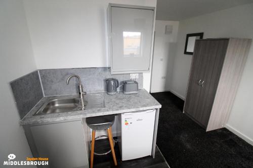 a small kitchen with a sink and a counter at Jayden House in Middlesbrough