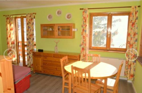 - une cuisine avec une table, une table et des chaises dans l'établissement House La Motta, à Borgata Sestriere