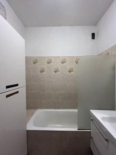 une salle de bain blanche avec une baignoire et un lavabo dans l'établissement Small Cosy Studio in Paris, à Paris