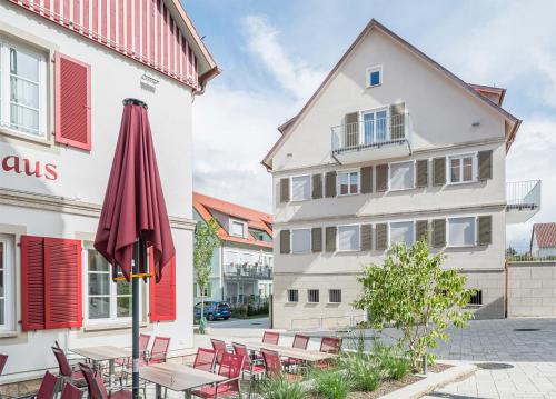 an umbrella and tables and chairs in front of a building at Altes Bräuhaus, Ferienwohnungen und Apartments in Gaildorf in Gaildorf
