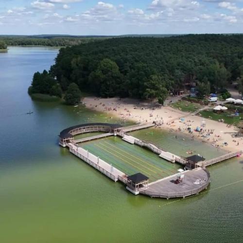 an island in a body of water with a beach at DOMEK W BRZOZACH nad jeziorem z balią na wyłączność in Lgiń
