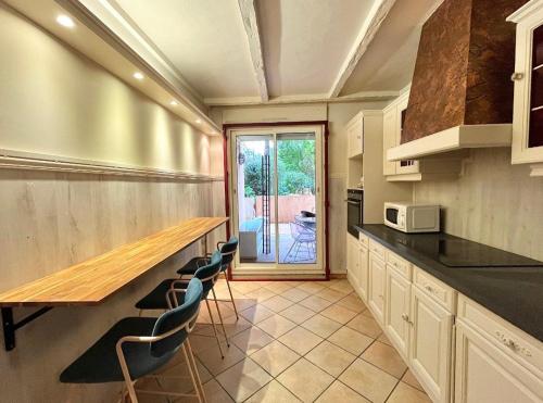 une cuisine avec un grand comptoir et des chaises dans l'établissement Calm and cosy 60m2 apartment near Matabiau station, à Toulouse
