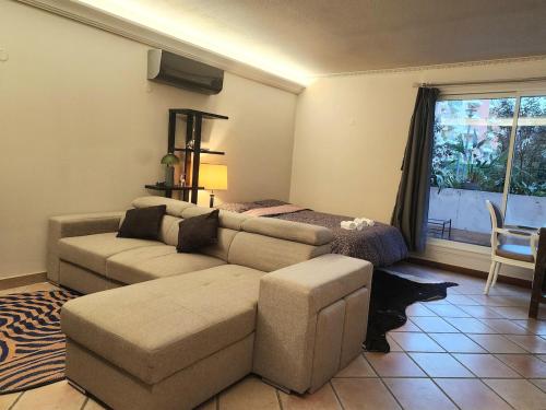 un salon avec un canapé et un lit dans l'établissement Calm and cosy 60m2 apartment near Matabiau station, à Toulouse