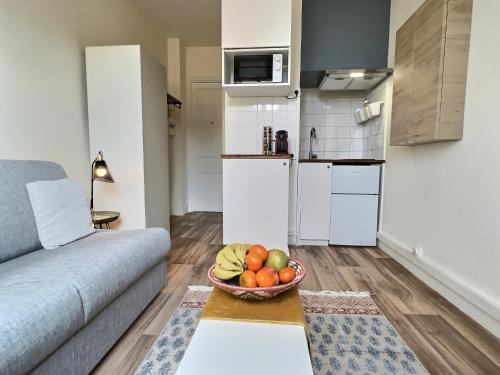 a living room with a bowl of fruit on a table at Studio Paris 14ièm-Montrouge in Montrouge