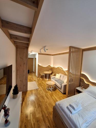 a room with a bed and a couch and a table at Apartman Vučko Dalia - Aparthotel Vučko in Jahorina