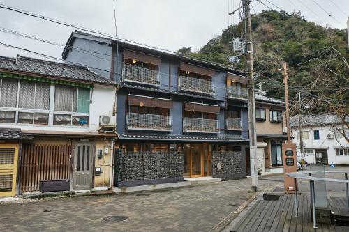 a building with balconies on the side of a street at TSUCHIYA Kinosaki onsen in Toyooka
