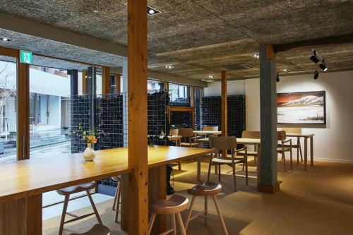 a dining room with wooden tables and chairs at TSUCHIYA Kinosaki onsen in Toyooka