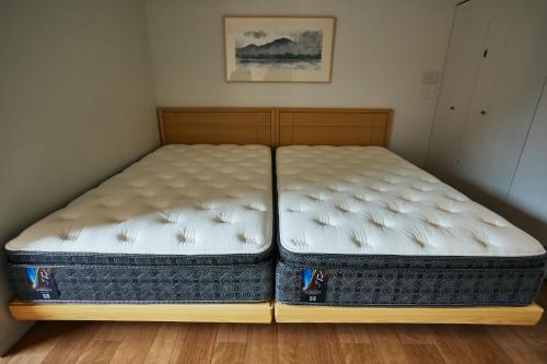 a bed with two mattresses sitting on the floor at TSUCHIYA Kinosaki onsen in Toyooka