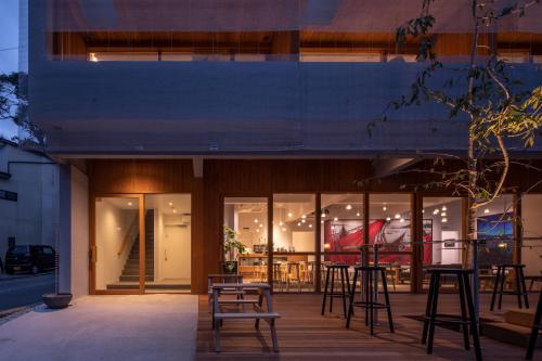 a building with chairs and tables in front of it at TSUCHIYA Kinosaki onsen in Toyooka