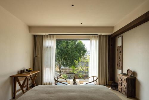 ブ源県にあるWuyuan Jingmuo Liangxi Guest Houseのベッドと大きな窓のある寝室