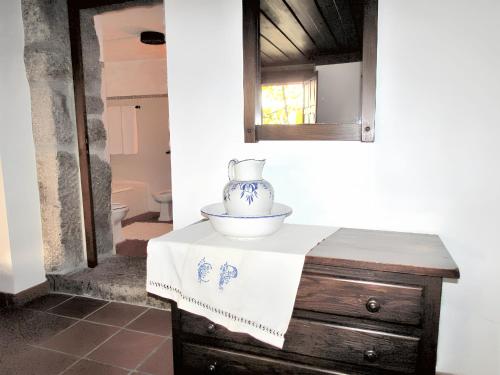 einen Tisch mit einer Vase darüber in der Unterkunft Charming house with fireplace, mountain view, Ponte da Barca in Pedras de Moledo