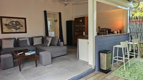 a living room with a couch and a table at Habitation Villa Les Cassias in Petit-Bourg