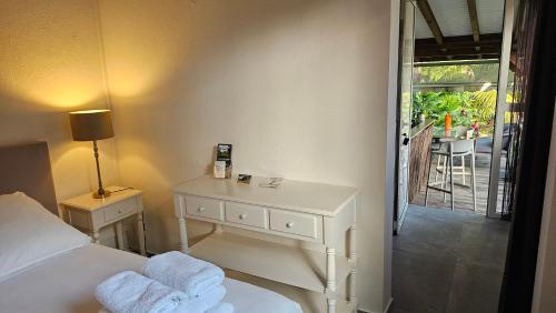 a bedroom with a bed and a table with towels at Habitation Villa Les Cassias in Petit-Bourg