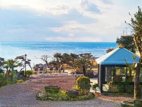 a small blue building with the ocean in the background at OROJEJU in Seogwipo