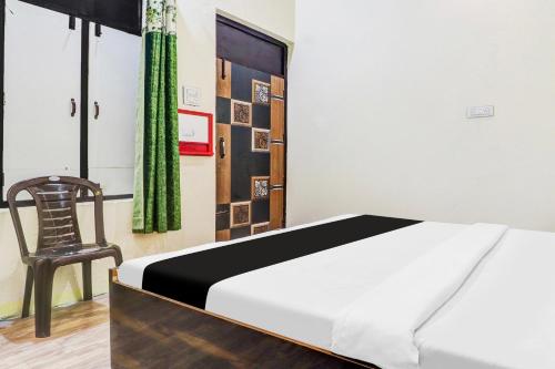 een slaapkamer met een bed en een stoel bij Hotel O IIDM ECO CENTRE in Lucknow