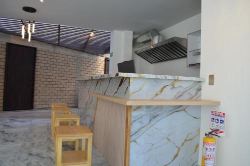 a kitchen with a counter with two stools in a room at Hotel Diamond Luxury Tunja in Tunja